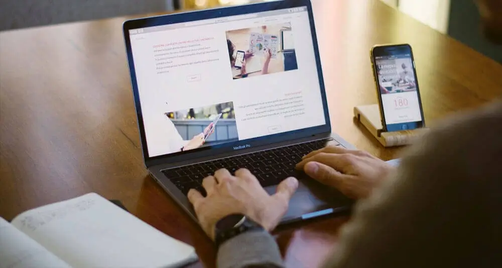 Visa consultant reviewing study abroad application on laptop and smartphone, providing comprehensive counselling services.