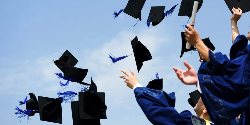 Graduates celebrating with cap toss, symbolizing successful scholarship opportunities for Indian students studying abroad