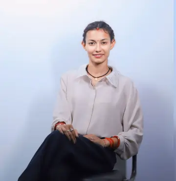 Anita Pokharia, receptionist at 13 Dreams Consultant, smiling in professional office portrait.